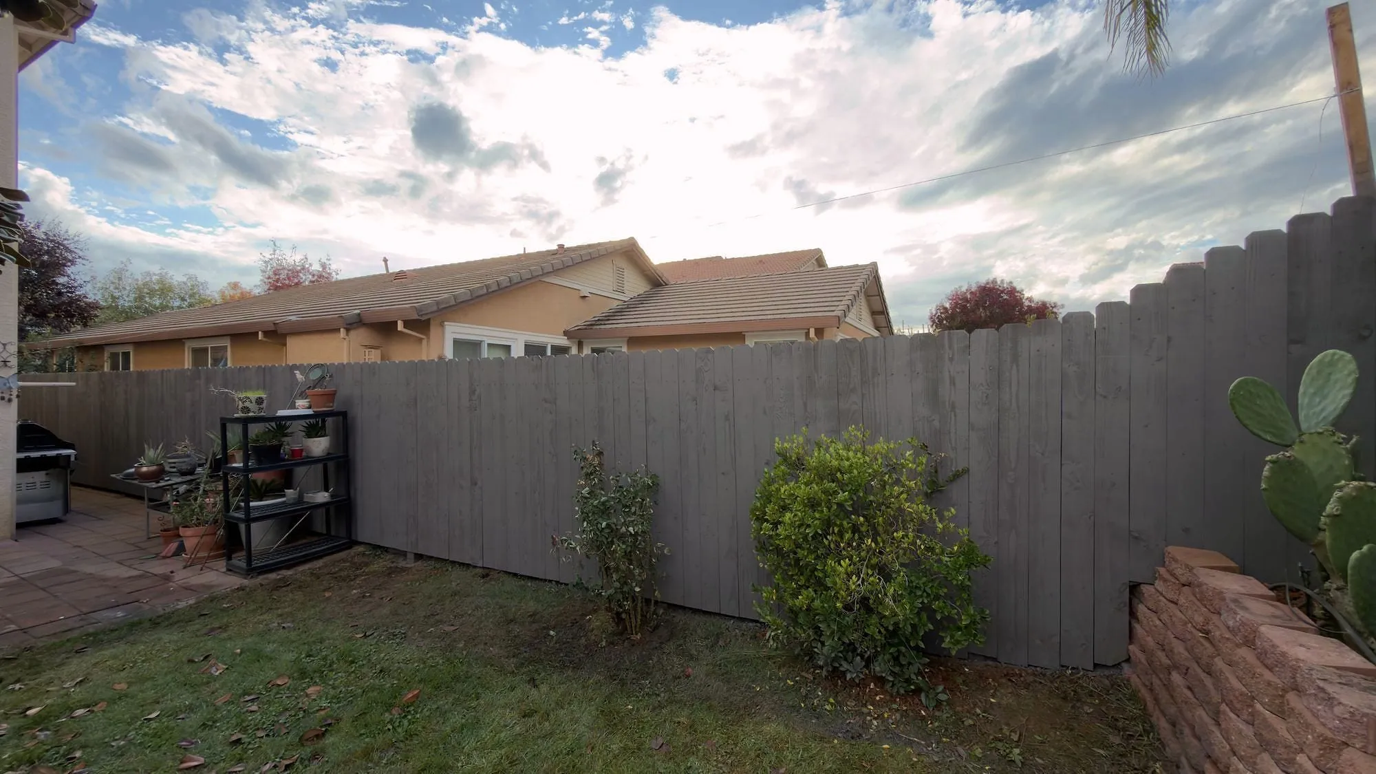 New gray timber fence running the full length of a Sacramento-area backyard