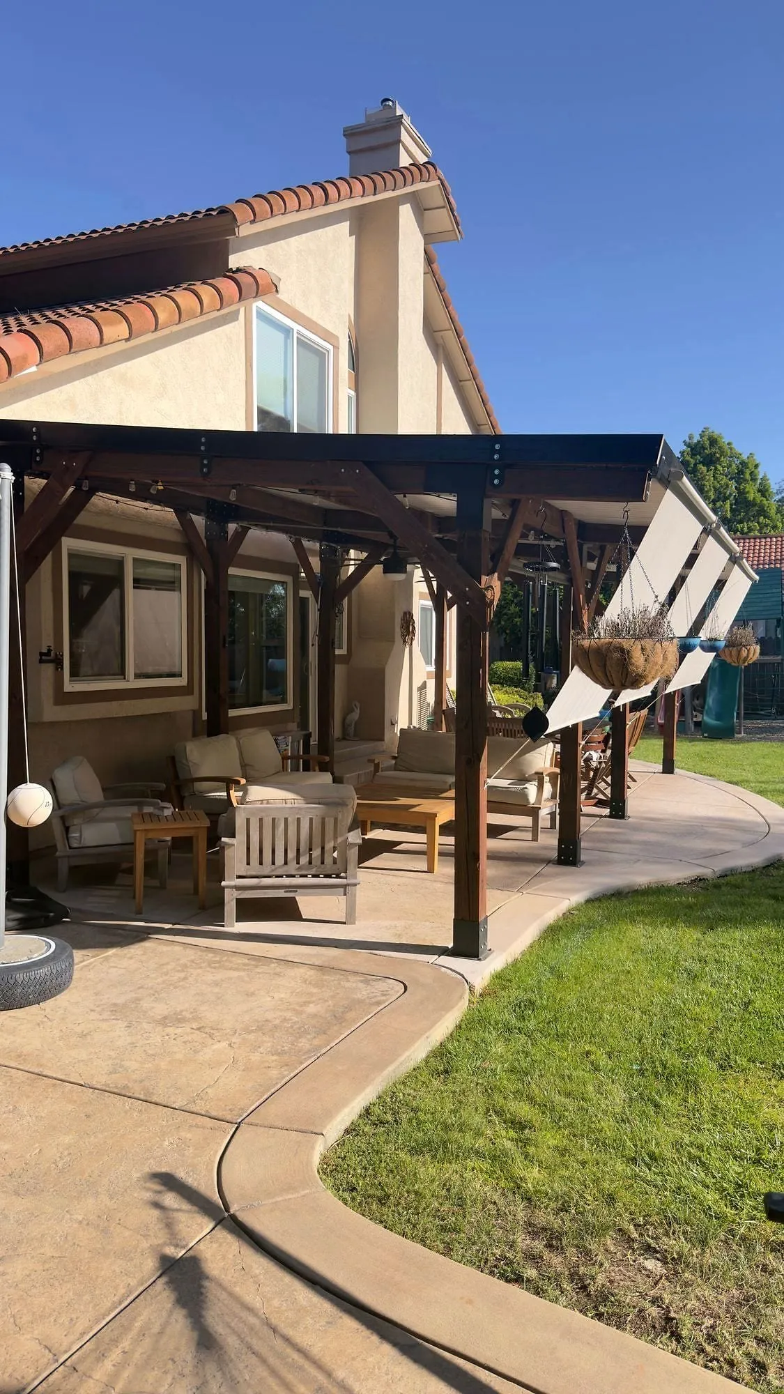 Finished timber patio cover on a Sacramento home, lit from underneath at golden hour